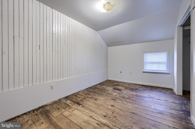 additional living space with vaulted ceiling and wood-type flooring