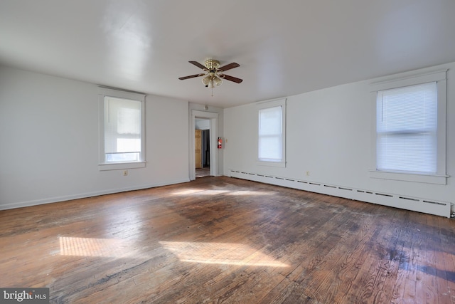 empty room with a baseboard heating unit, ceiling fan, and wood-type flooring