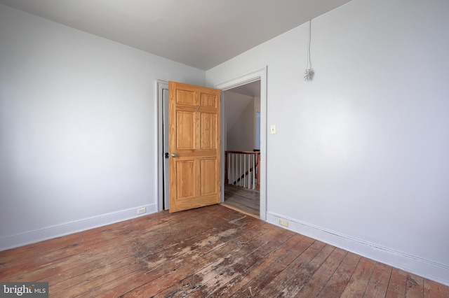 unfurnished room featuring baseboards and hardwood / wood-style flooring