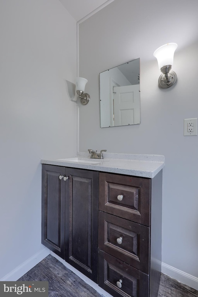 bathroom with baseboards, wood finished floors, and vanity