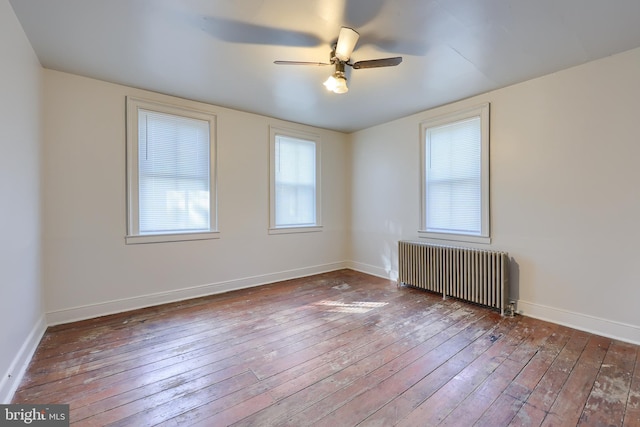 spare room with hardwood / wood-style floors, radiator heating unit, and baseboards