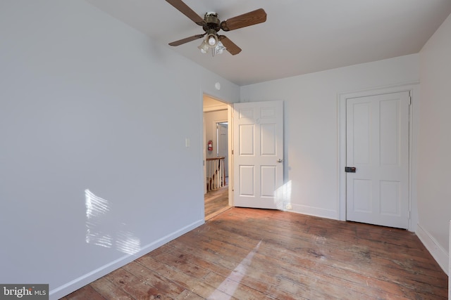 unfurnished bedroom with a ceiling fan, baseboards, and wood-type flooring