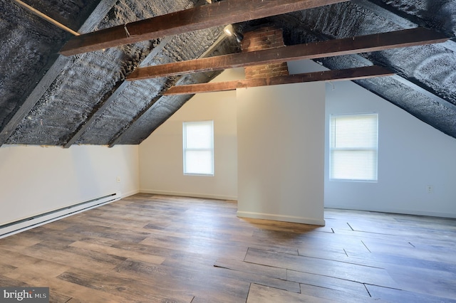 additional living space with baseboards, baseboard heating, wood finished floors, and vaulted ceiling with beams