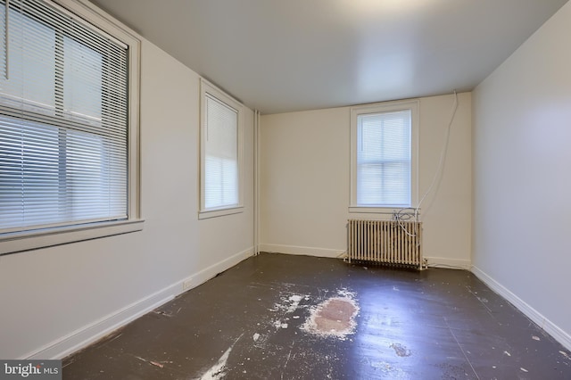 spare room with radiator and baseboards