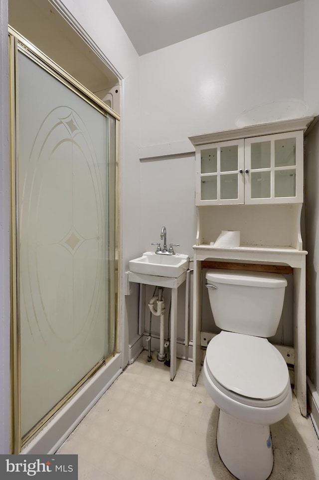 bathroom featuring tile patterned floors, a stall shower, and toilet