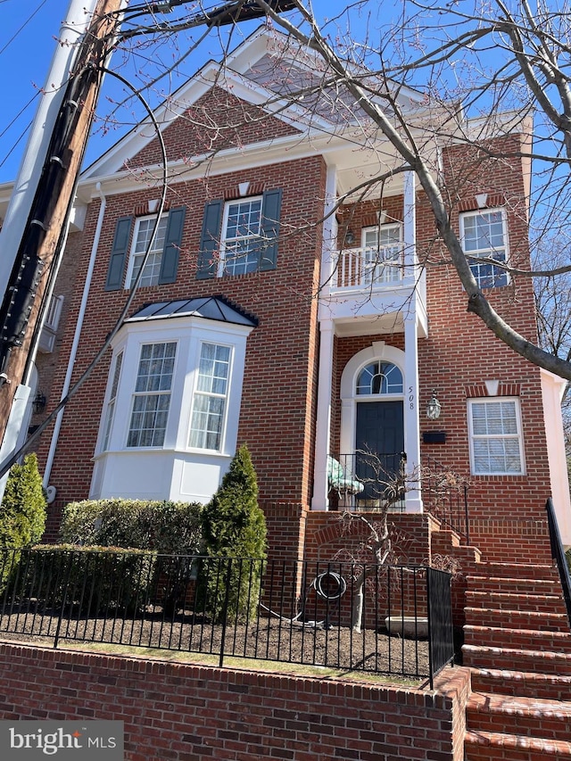 view of front of home featuring a fenced front yard and brick siding