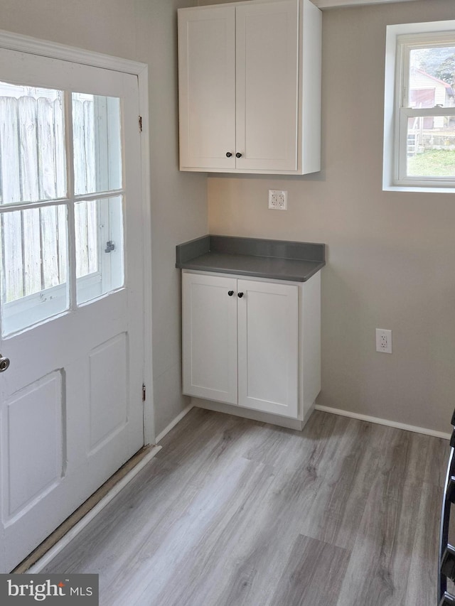 washroom with light wood-style flooring and baseboards