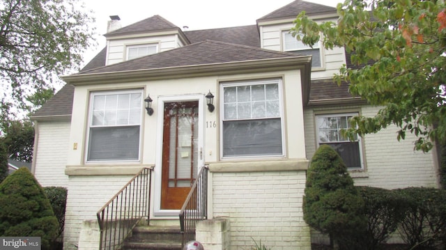 view of front of property featuring brick siding and a shingled roof