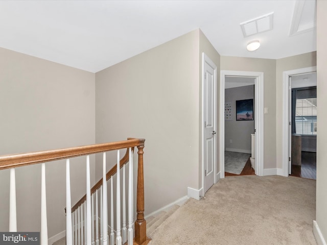 corridor featuring an upstairs landing, visible vents, carpet floors, and baseboards