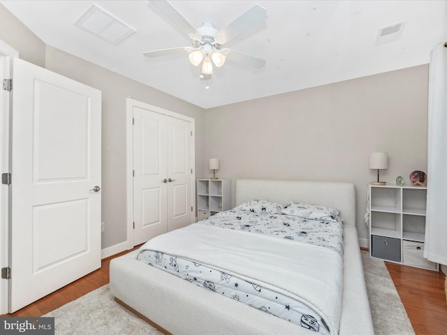 bedroom with visible vents, baseboards, and wood finished floors