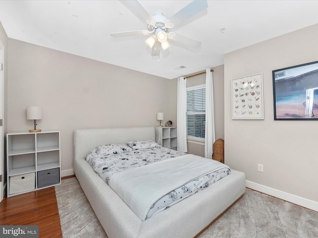 bedroom featuring ceiling fan, baseboards, and wood finished floors