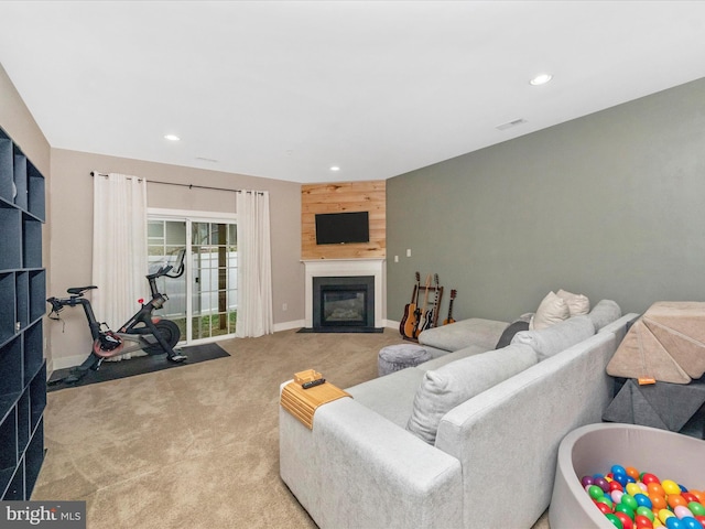 living area with carpet flooring, recessed lighting, visible vents, and a fireplace with flush hearth