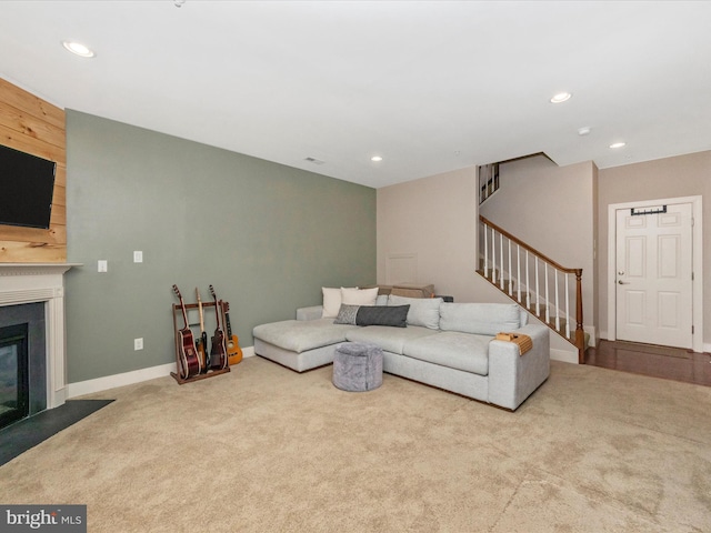 carpeted living area with recessed lighting, stairway, a fireplace with flush hearth, and baseboards