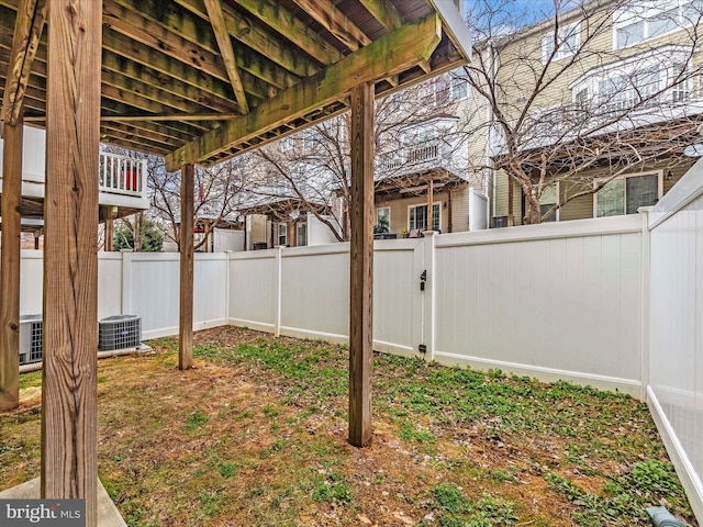 view of yard with central AC unit and a fenced backyard