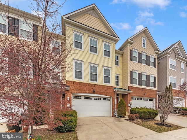 townhome / multi-family property with an attached garage, brick siding, and driveway