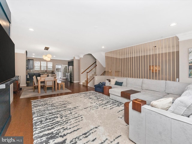 living area with recessed lighting, stairway, wood finished floors, and ornamental molding