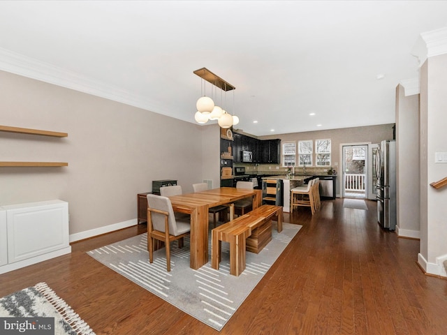 dining space featuring dark wood-style floors, recessed lighting, crown molding, and baseboards