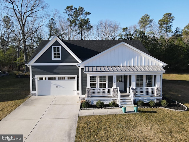 view of front of home with board and batten siding, covered porch, concrete driveway, and a front lawn