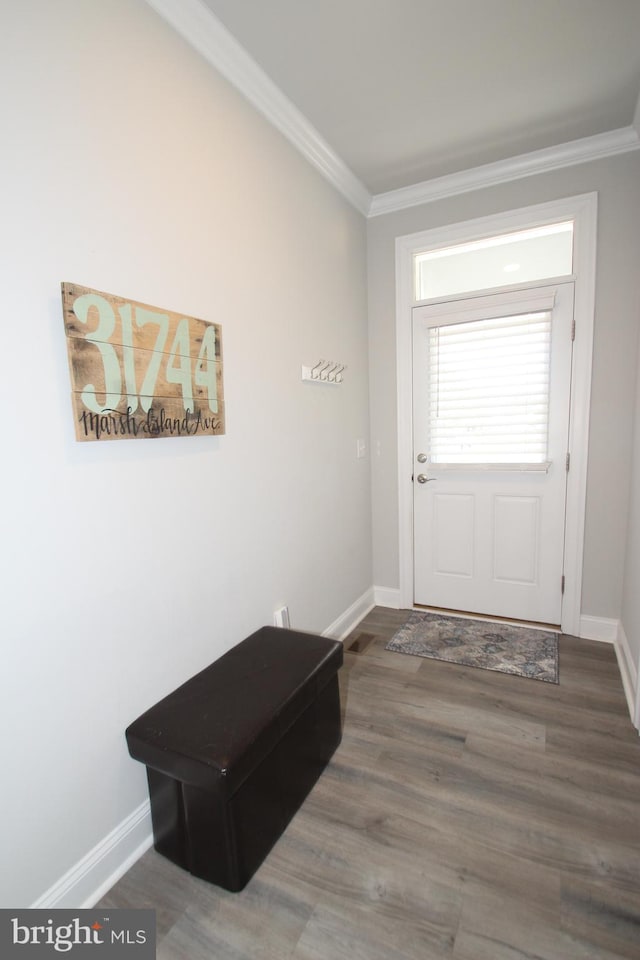 doorway with baseboards, wood finished floors, and ornamental molding