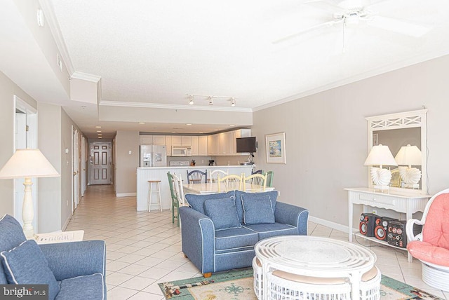 living room with light tile patterned floors, ceiling fan, crown molding, and baseboards