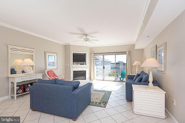 living area featuring a textured ceiling, a high end fireplace, crown molding, light tile patterned floors, and baseboards