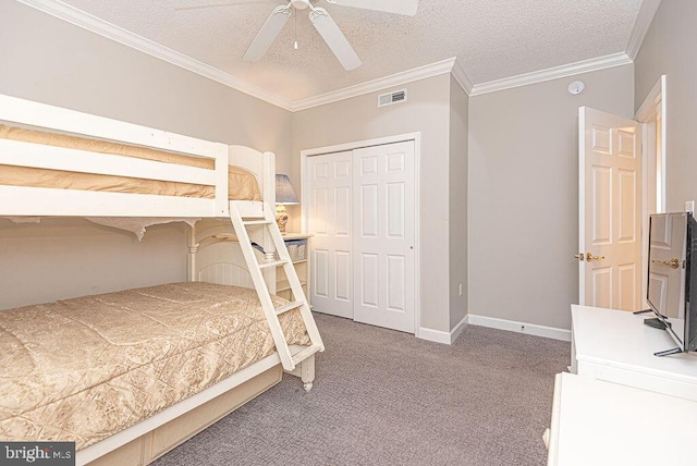 bedroom with visible vents, ornamental molding, a textured ceiling, a closet, and carpet flooring