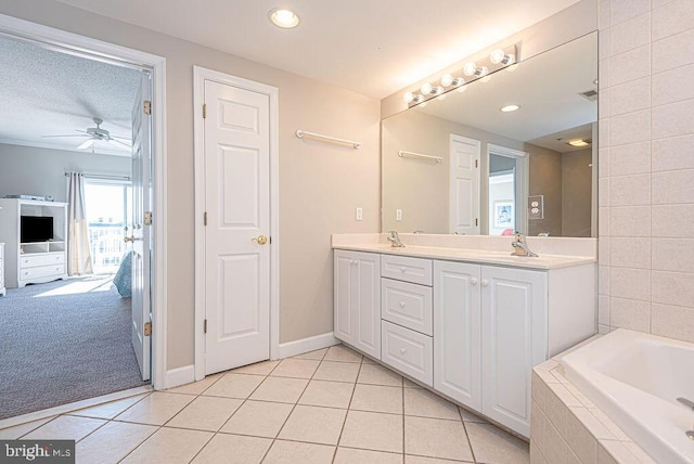 bathroom featuring double vanity, a relaxing tiled tub, a sink, and tile patterned flooring