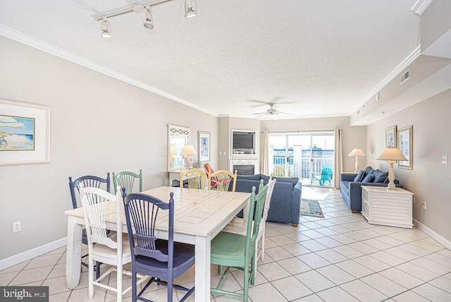 dining room with visible vents, ornamental molding, a textured ceiling, a fireplace, and light tile patterned floors