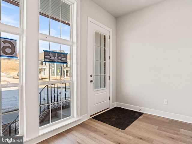 doorway to outside with baseboards and wood finished floors