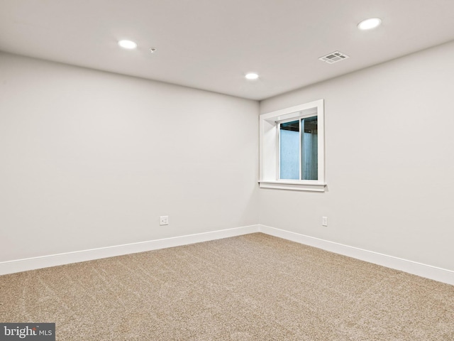 carpeted spare room featuring recessed lighting, visible vents, and baseboards