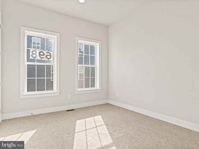 spare room with carpet flooring, recessed lighting, visible vents, and baseboards