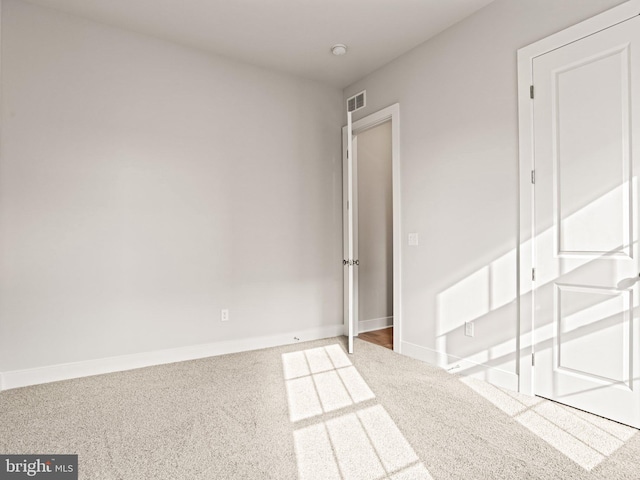 unfurnished bedroom featuring carpet flooring, visible vents, and baseboards