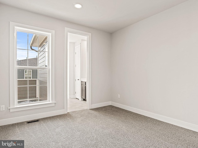 spare room with recessed lighting, visible vents, carpet flooring, and baseboards