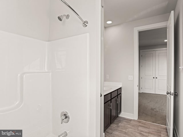 bathroom with vanity, shower / bathtub combination, and baseboards