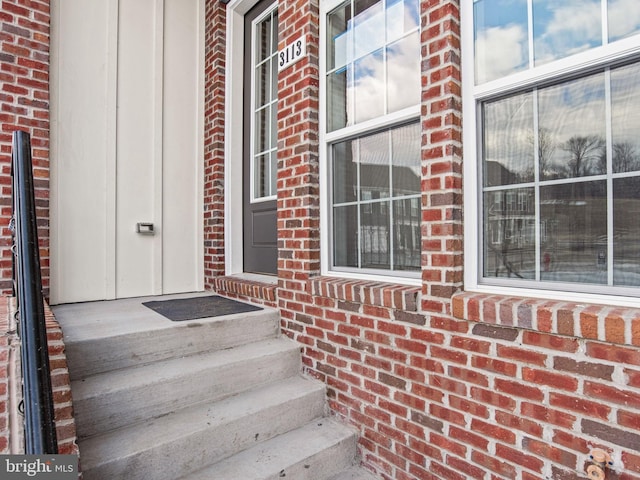 entrance to property featuring brick siding