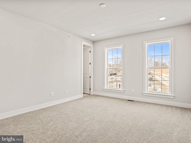 carpeted spare room featuring visible vents, recessed lighting, and baseboards