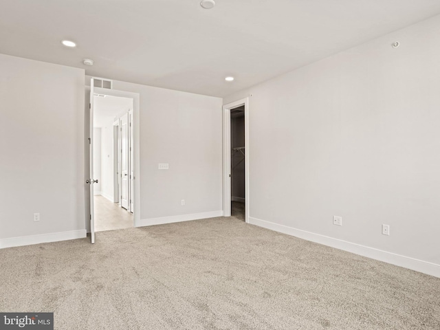 spare room featuring carpet flooring, recessed lighting, visible vents, and baseboards