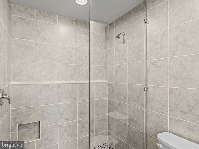 full bathroom featuring a stall shower and toilet