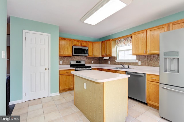 kitchen with a sink, tasteful backsplash, stainless steel appliances, light tile patterned flooring, and light countertops