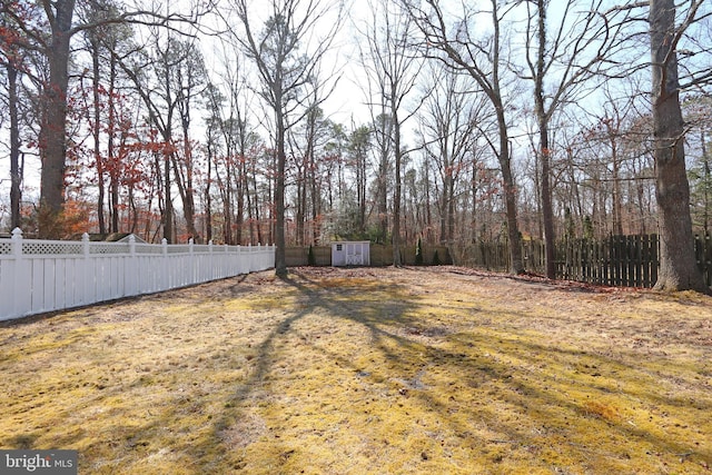 view of yard with an outdoor structure, fence private yard, and a shed