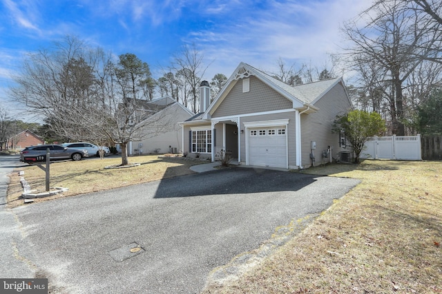 view of front facade featuring a front yard, central AC unit, fence, a garage, and aphalt driveway