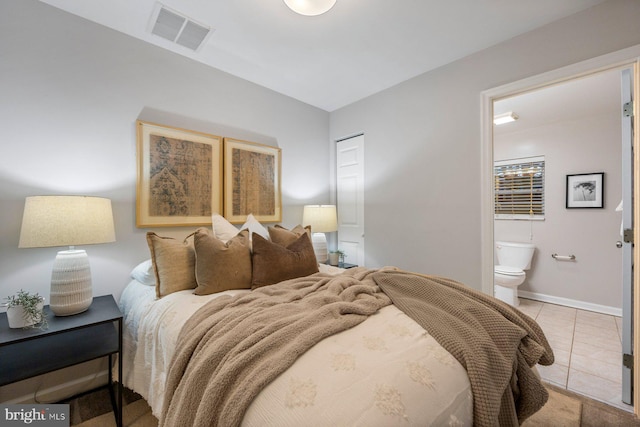 bedroom with light tile patterned floors, baseboards, visible vents, and ensuite bathroom