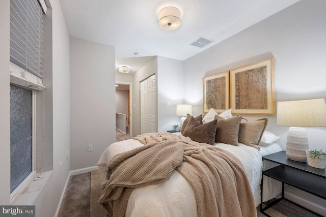 bedroom featuring a closet, visible vents, baseboards, and carpet floors