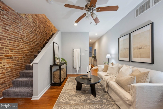 living area featuring visible vents, a ceiling fan, wood finished floors, stairway, and baseboards