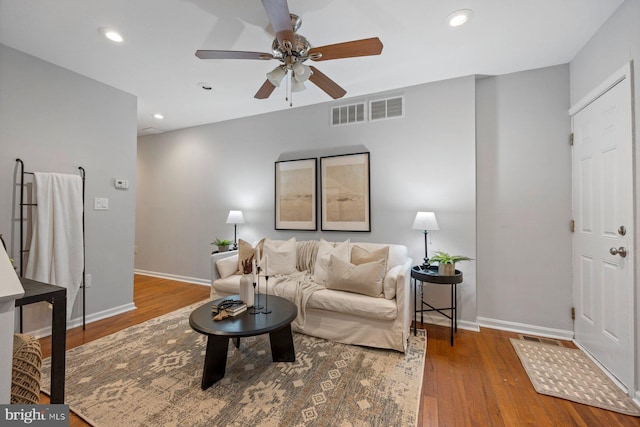living room with visible vents, baseboards, ceiling fan, and wood finished floors