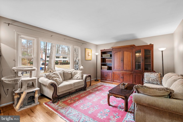 living area with baseboards and light wood-type flooring