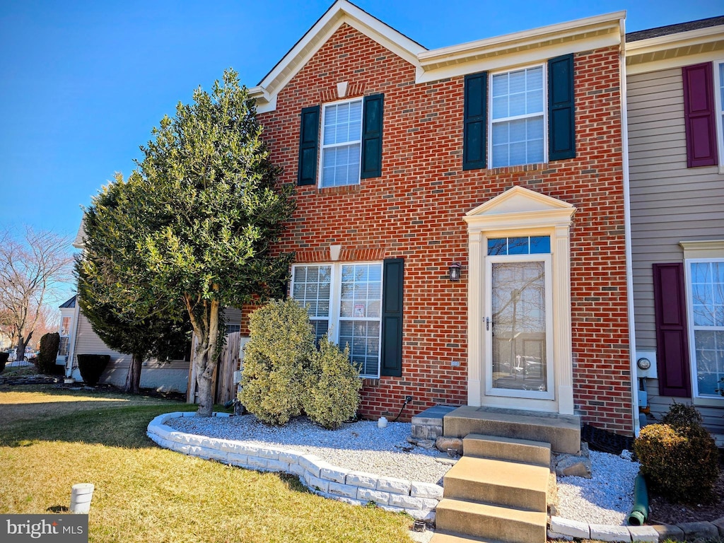 view of front of property with brick siding and a front lawn