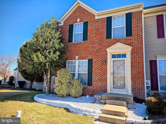 view of front of property with brick siding and a front lawn