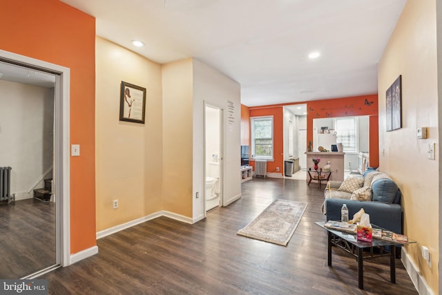 living room with baseboards, dark wood-style flooring, and radiator