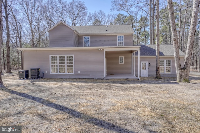 back of house featuring cooling unit and a shingled roof